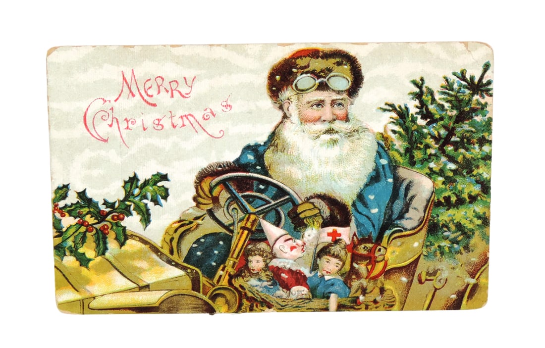 Christmas Postcard, Santa in blue suit driving a car full of toys, marked M (1 of 2)