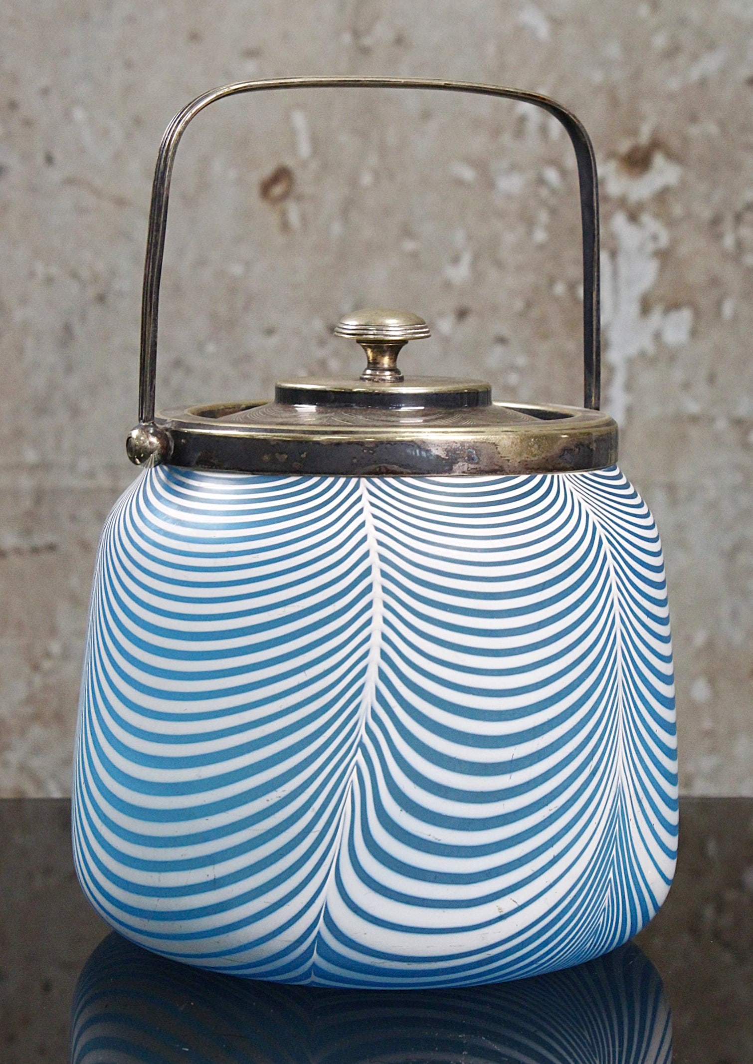 A Stevens & Williams Nailsea Art Glass Biscuit Jar: Pulled white drapes on blue satin, silvered lid with worn presentation inscription dtd 1891, Exc cond. 6"H excluding handle.