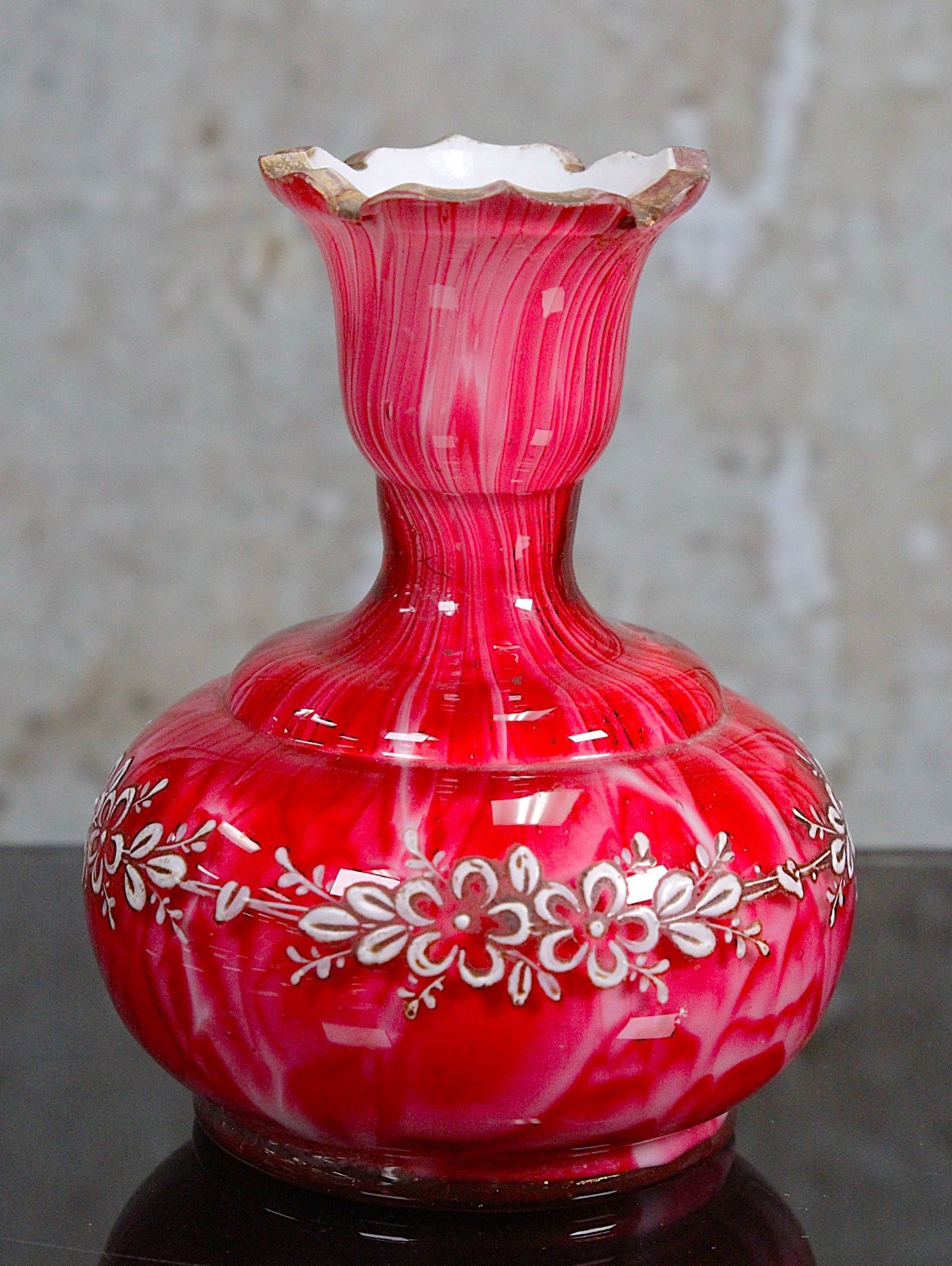 A Loetz Carneol Victorian Art Glass Vase: In ruby marbleized opal glass with scallop cut rim and enameled flowers, VG+ cond. with worn gilt, 4.5"H.
