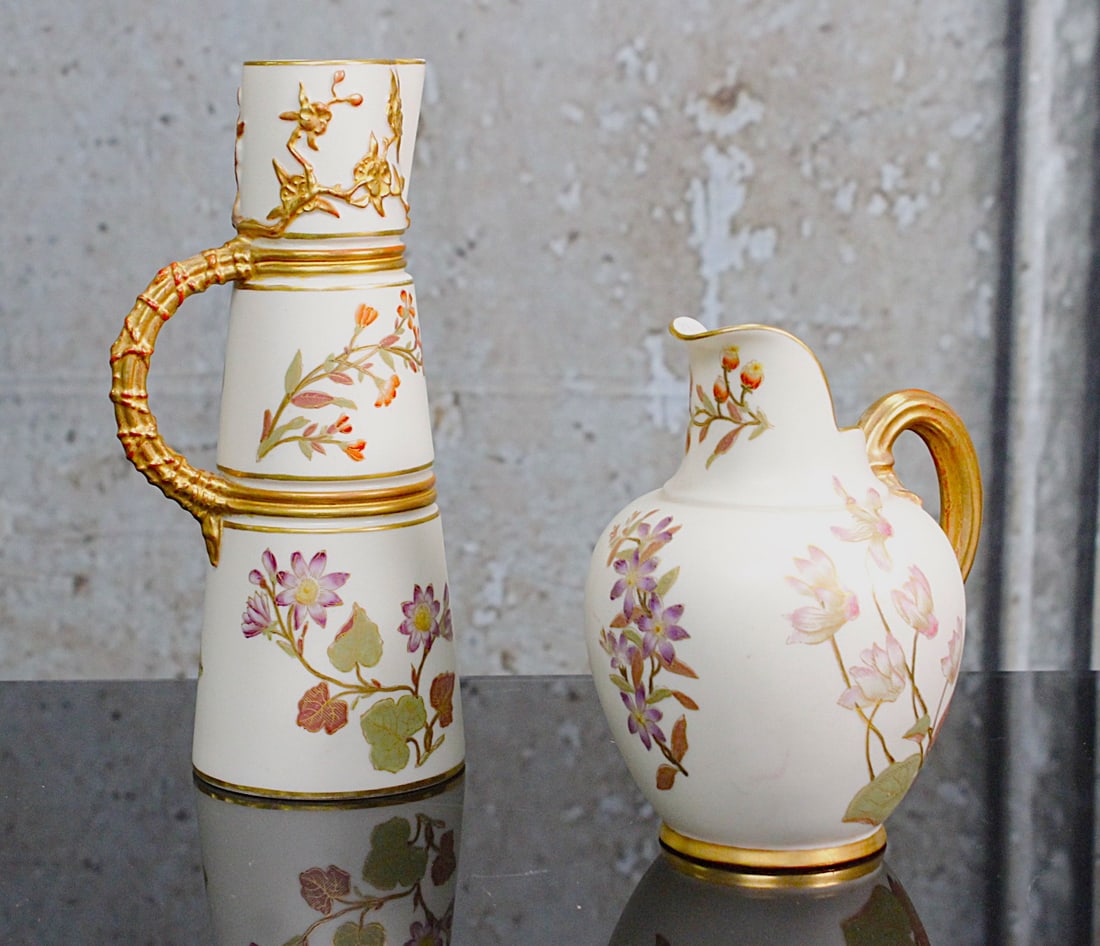 A Pair Of Royal Worcester Victorian Porcelain Jugs: 19th century with hand painted florals traced in gilt on a satin ground, Exc. cond, Largest 8"H.
