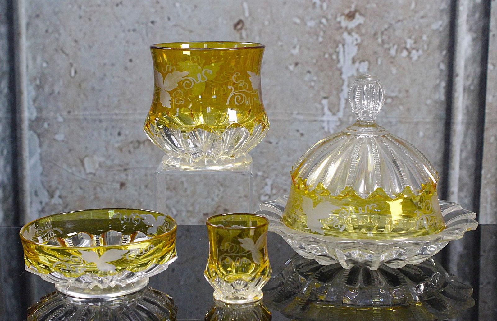 4 Pc Victorian Starburst Ivy Table Setting: 19th century in citron flashed glass cut to clear comprising a covered butter, sugar bowl, sauce bowl & toothpick holder, Mostly Exc. cond the butter base w/a small chip. Largest 7.5"Dia.
