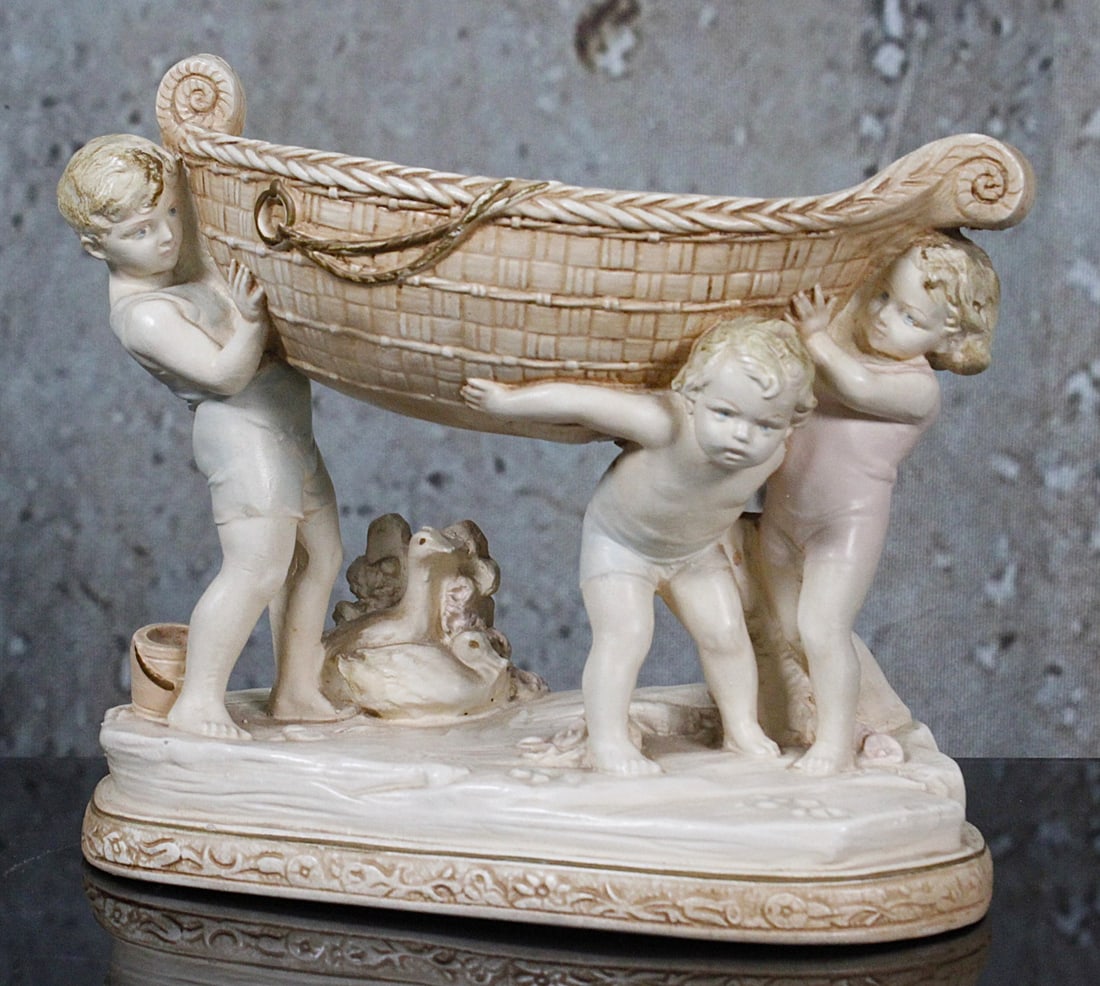 A Alexander Backer Neo-Classic Compote: Painted chalkware of three children holding a basket, signed on verso, Exc cond. 9.5"L.