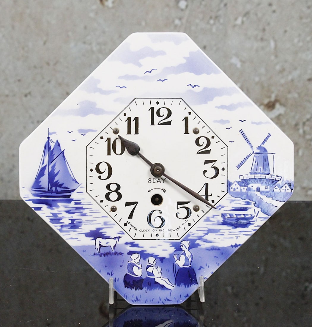A Newark Kitchen Wall Clock: Blue/white decorated Dutch harbor scene w/8 day movement in VG+ cond, 9.75"W.