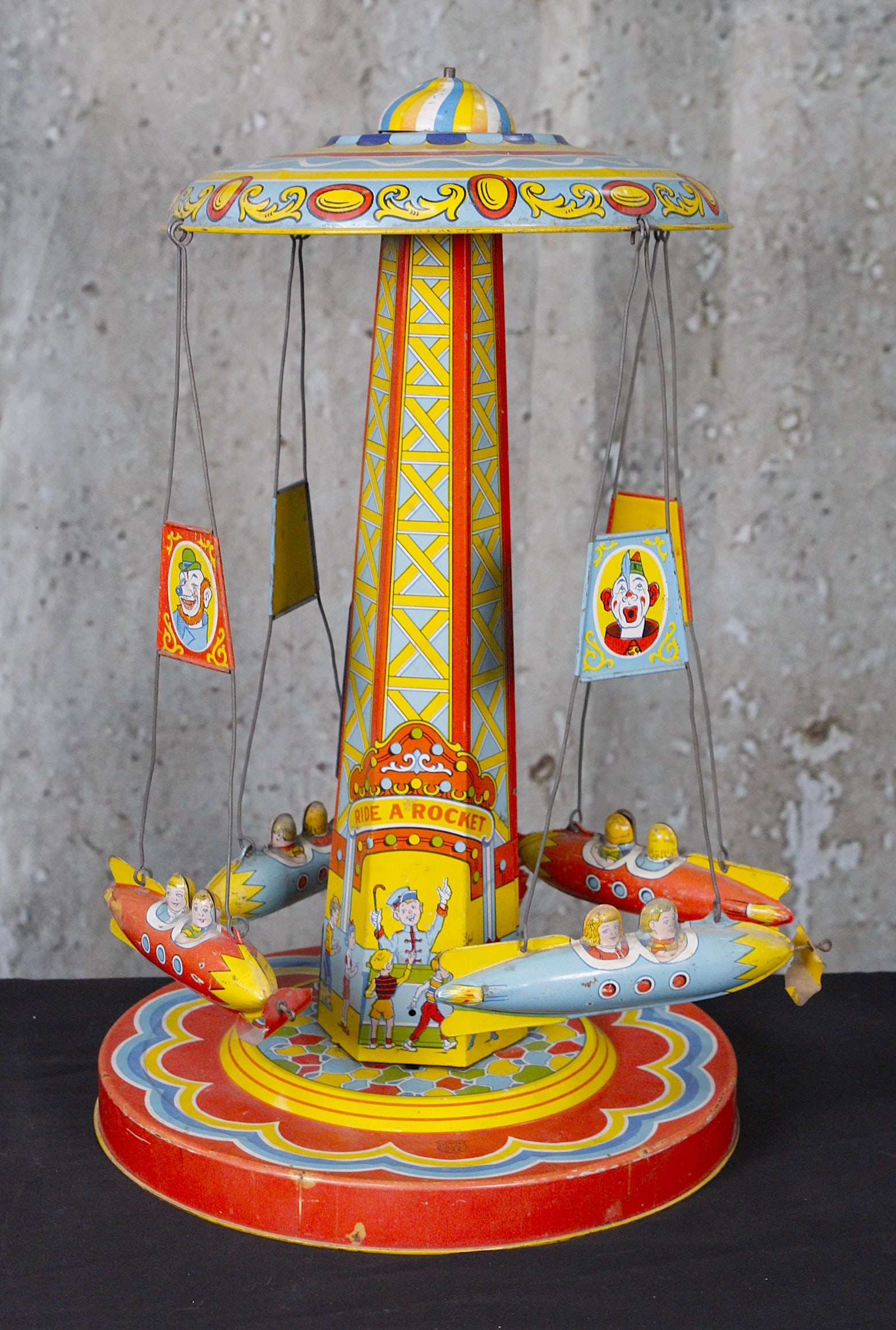 A Chein "Ride A Rocket" Wind-Up Toy: Tin litho c.1930s VG working cond noting propellers mostly absent 18"H.