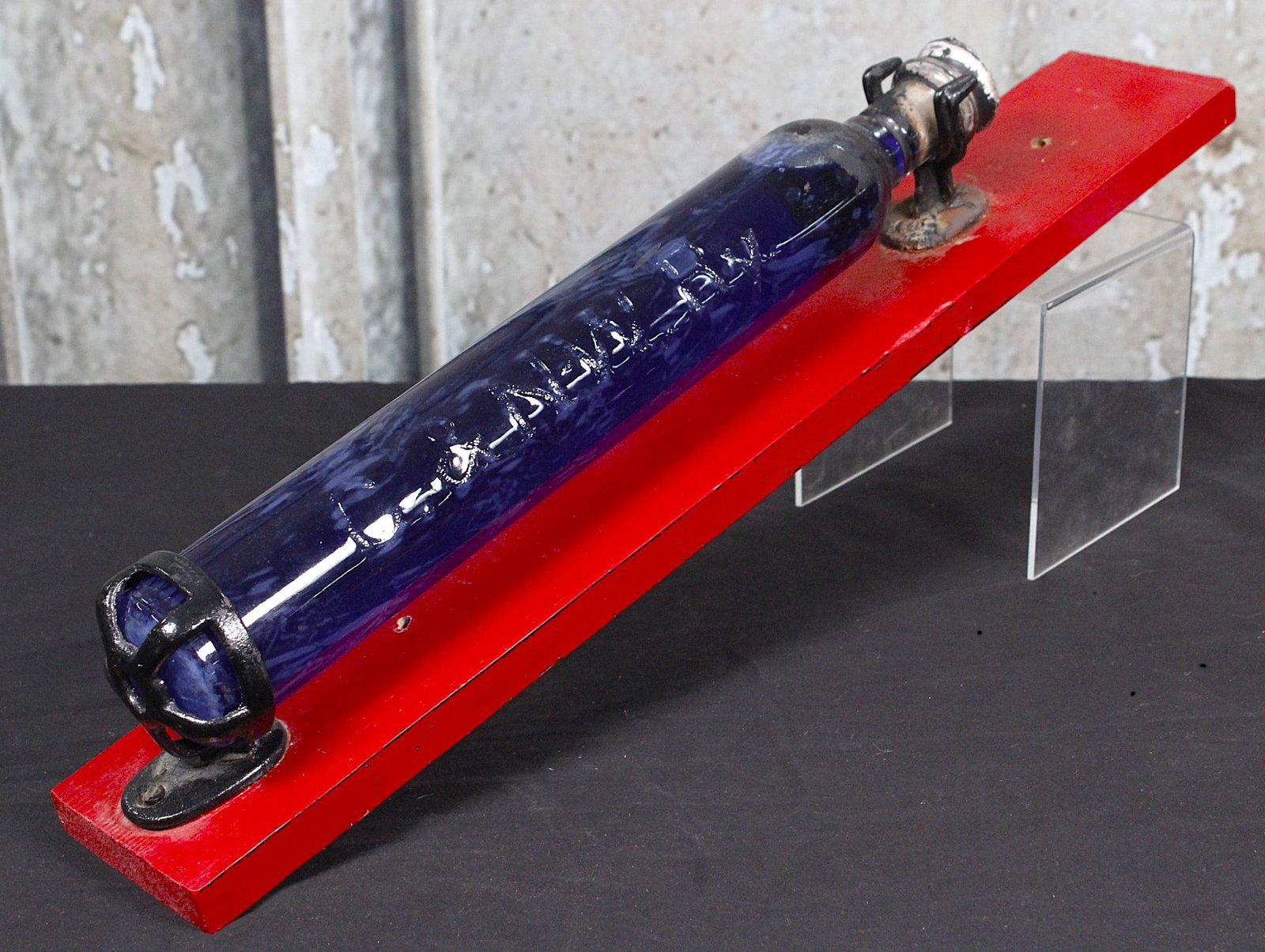 A Chicago & NorthWestern Railway Glass Fire Extinguisher: Early 20th century glass with embossed initials & cast iron brackets on later back board, VG+ cond. 24"L.
