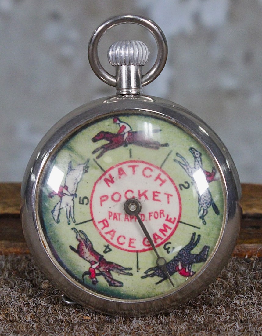 A Natch Pocket Race Game: Pocket watch form and hand spins when stem wound to land on 1 of 5 horses, Exc working cond. 2"Dia.