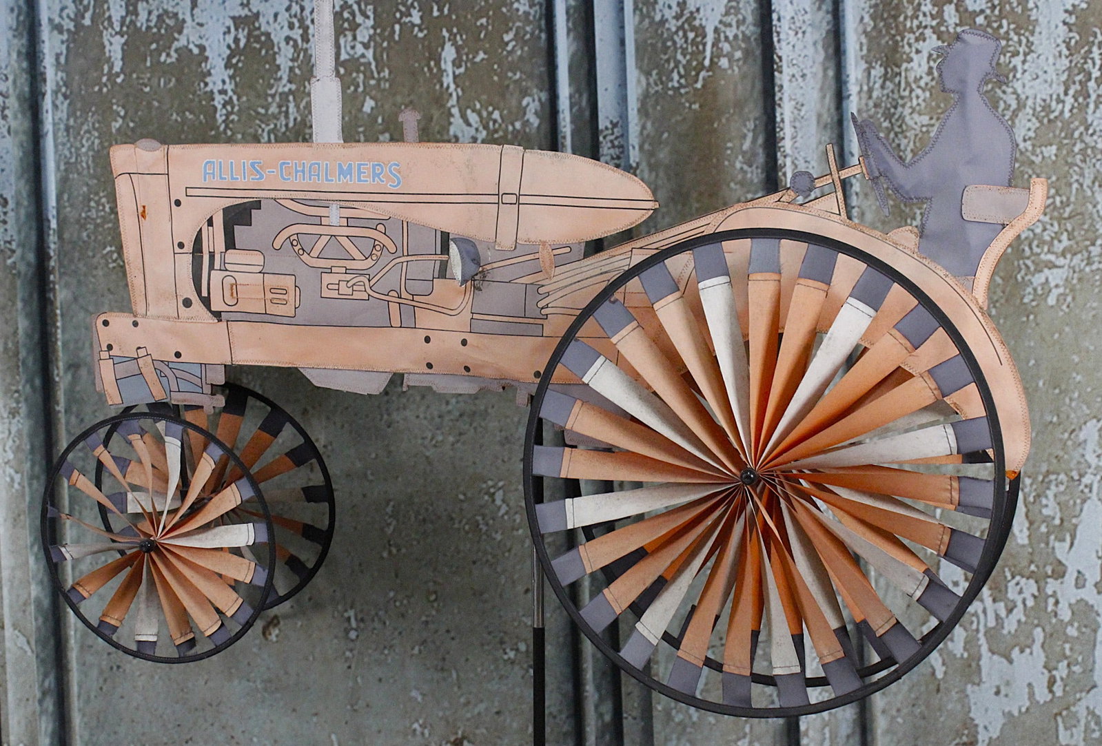 An Allis-Chalmers Tractor Whirlygig Lawn Ornament: Die-cut and stitched colored oil cloths with printed details, VG working condition noting color fade 26"H x 41"L excluding pole.