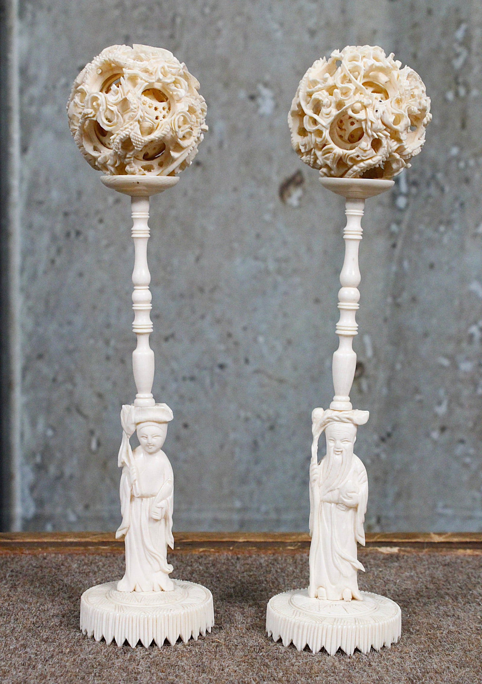 A Matched Pair Of Chinese Carved Puzzle Balls: Early 20th century with Tsang King Kae factory labels on base. Exc cond. 9"H & 2"Dia. Note: these cannot be shipped International and some US states may have restrictions.