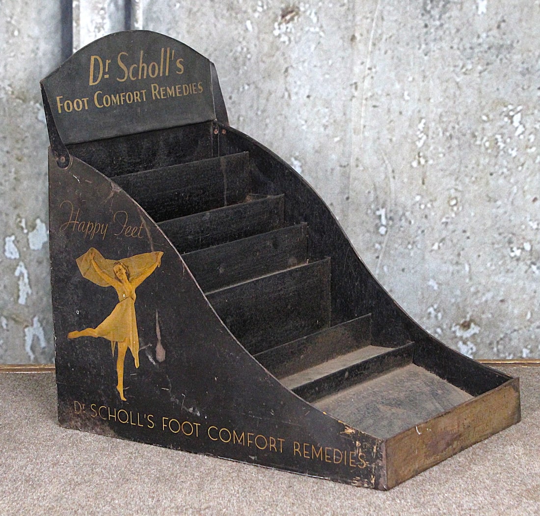 A Dr. Scholl's "Happy Feet" Counter Display: Multi-tiered tin litho with folding marquee and scene of a dancing woman, dtd 1936, G+ cond w/wear, 17"H x 12"W x 16.5"D.