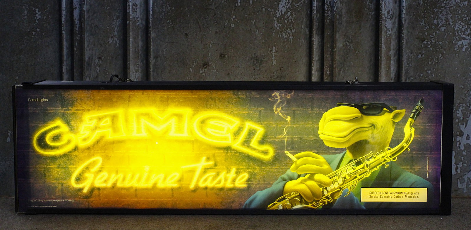 A Joe Camel-Cigarettes Lighted Sign: 1994 R.J. Reynolds with transparent graphics on each side, VG working cond w/some color fade, 49"L x 12"H x 6"W.