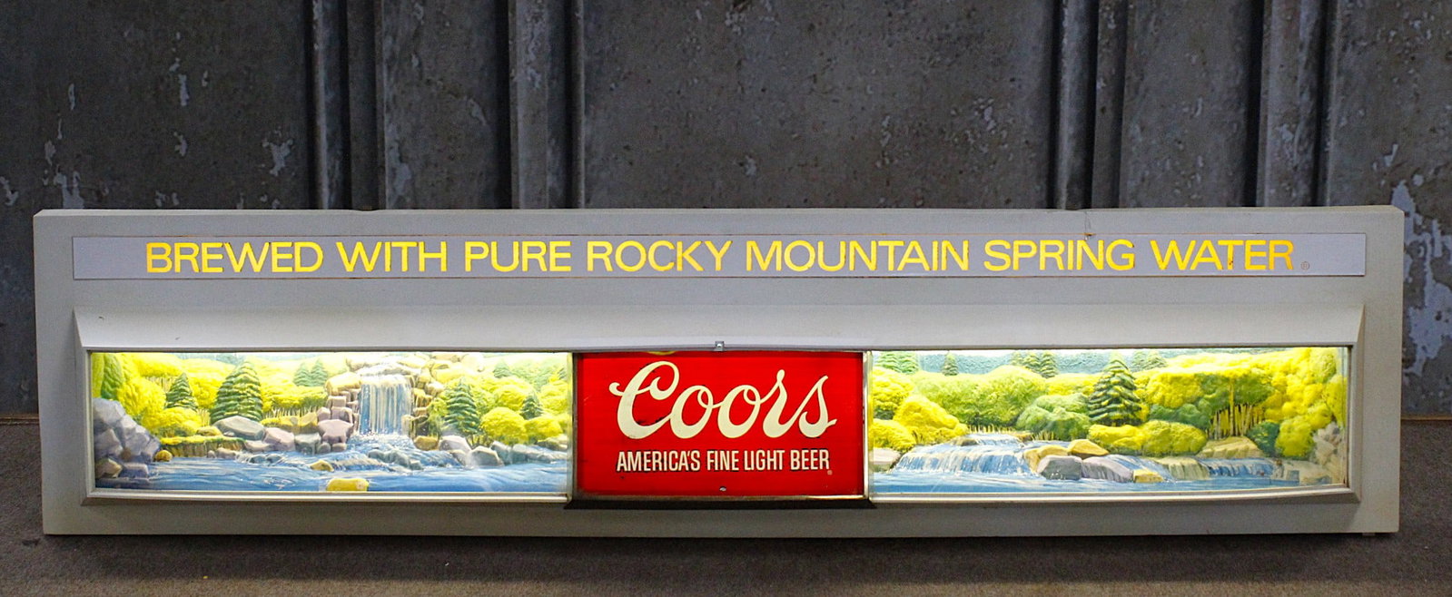 A Coors Beer Lighted Advertising Sign: Dated 1976 with 3-dimensional waterfall scenes, G+ working cond. 51"L x 12"H.