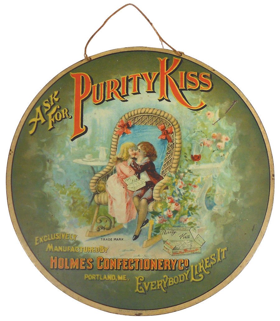 Advertising sign, Purity Kiss, mfgd by Holmes Confectio: Advertising sign, Purity Kiss, mfgd by Holmes Confectionery Co.-Portland, ME, litho on diecut metal by Savage Mfg Co.-New York, great graphics, Good/VG cond w/some wear & scratch, 8"Dia.
