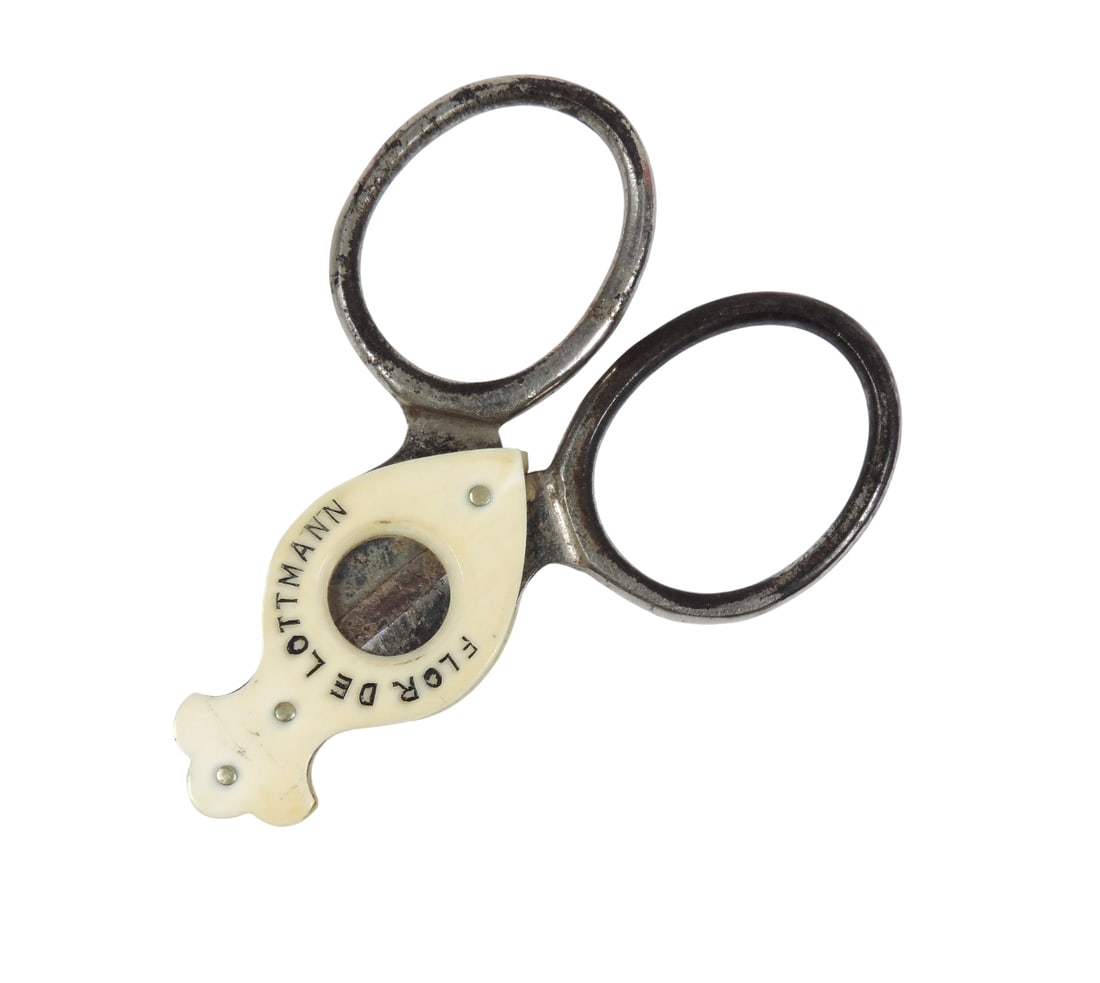 Cigar Cutter, scissor-style cutter featuring two rings for the fingers & sharp blades to slice th...: Cigar Cutter, scissor-style cutter featuring two rings for the fingers & sharp blades to slice the cigar, possibly bone/metal, embossed Havana Cigars/Flor De Lottmann/Germany, c. early 1900s, VG cond
