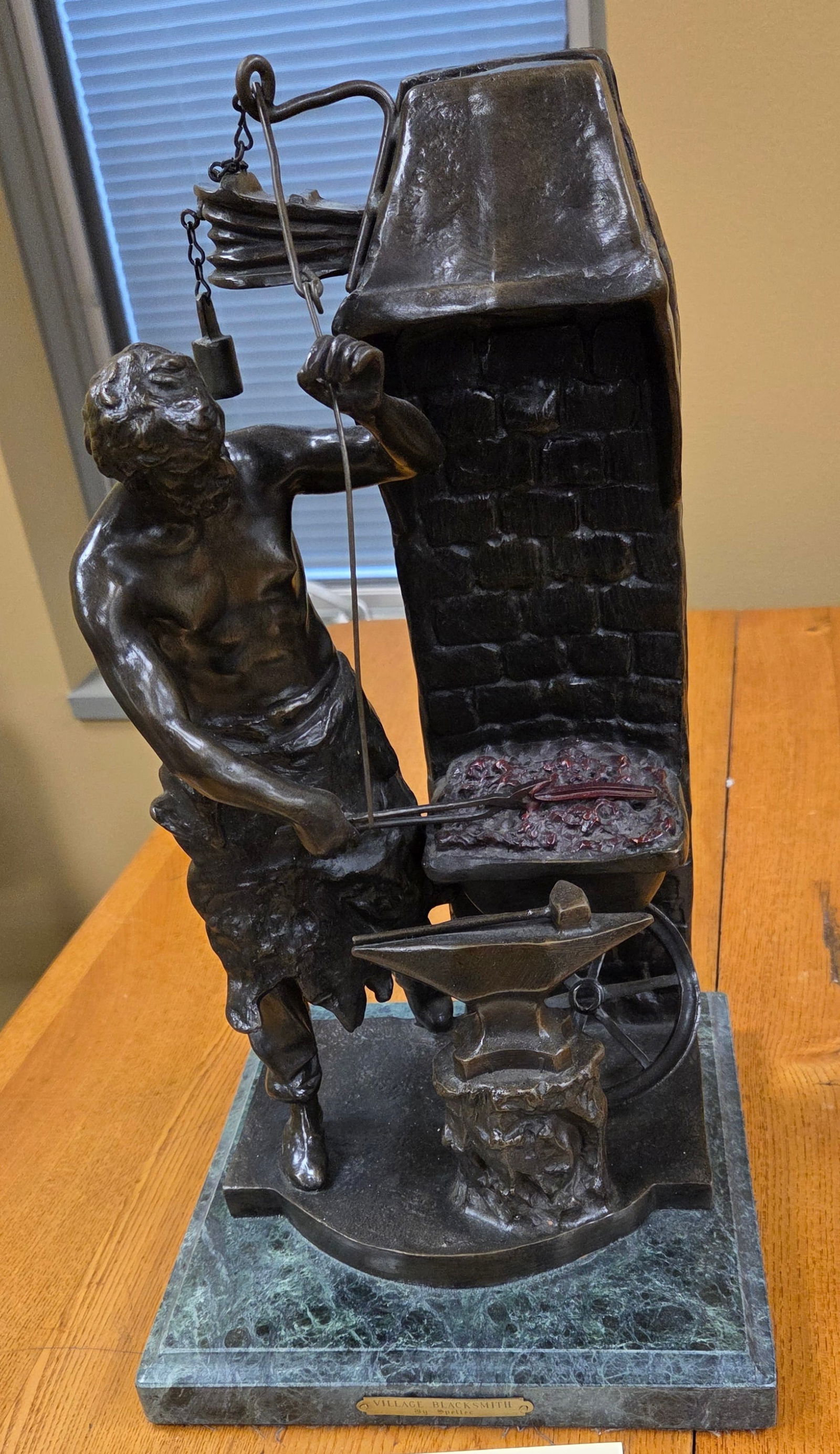 Bronze sculpture sculpture on a marble base of a blacksmith swinging a hammer at a piece of metal on (1 of 1)