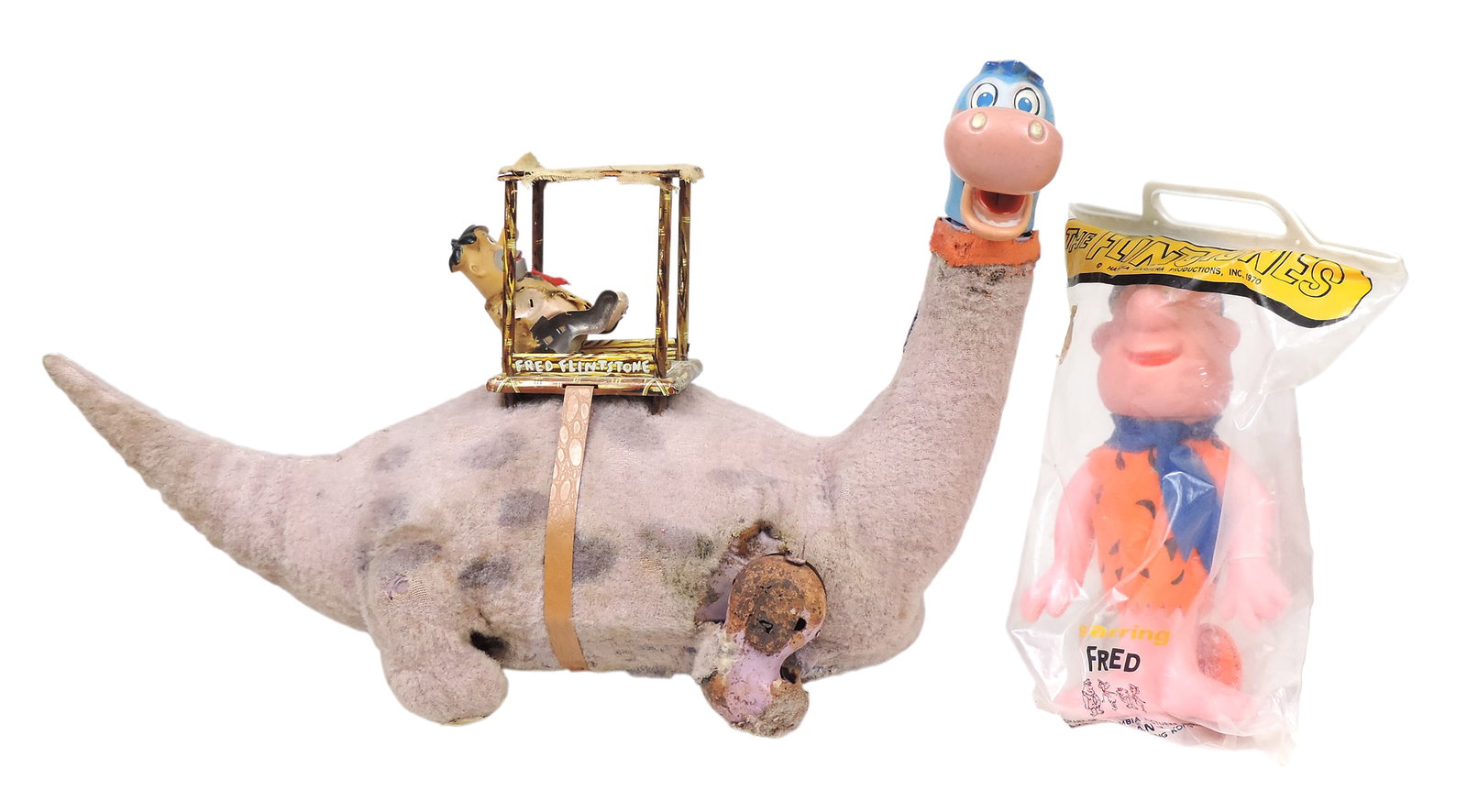 Marx Dino & The Flintstones Fred toys(2), Fred, plastic in orig packaging, R. Dakin & Co., San F...: Marx Dino & The Flintstones Fred toys(2), Fred, plastic in orig packaging, R. Dakin & Co., San Francisco, product of Hong Kong & Marx Flintstones "Fred on Dino", battery operated, c. 1960s, shows wear