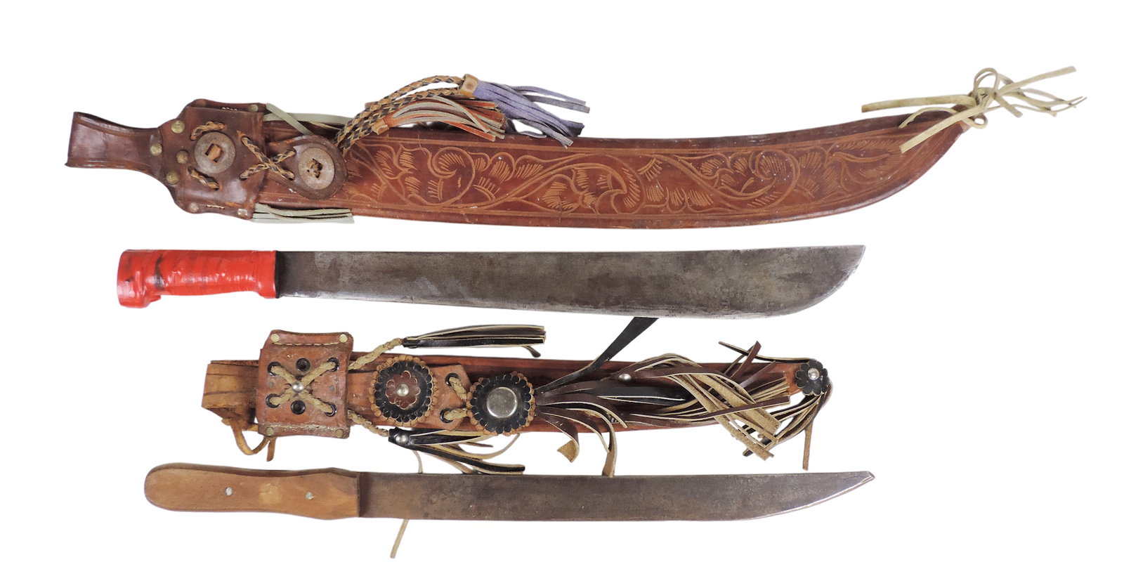 Machetes & Leather Sheathes (2), ornate hand-tooled leather sheathes w/decorative fringe/tassels,...: Machetes & Leather Sheathes (2), ornate hand-tooled leather sheathes w/decorative fringe/tassels, one marked Honduras/Troy, medal blades, VG cond w/age-related wear (enlarge photos for details), up to