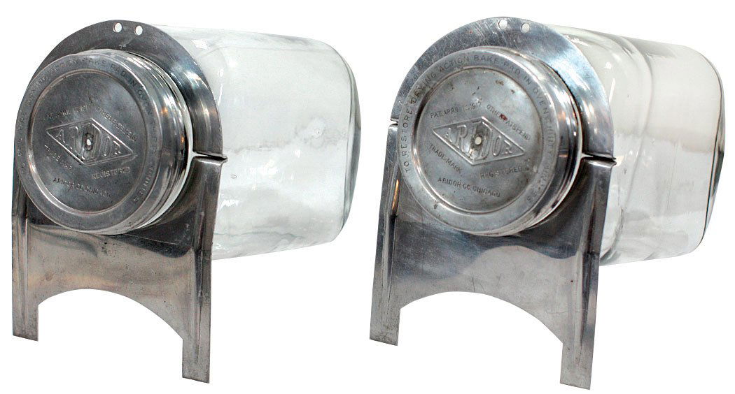 Candy display jars (2), "Aridor" horizontal glass jars: Candy display jars (2), "Aridor" horizontal glass jars w/aluminum lids & stands, dated 1917, VG cond, 10"H x 7"W x 13"D.