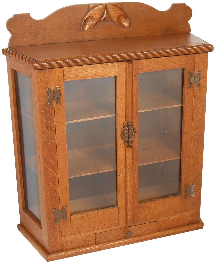 Furniture, wall cabinet, oak w/angled sides, rope: Furniture, wall cabinet, oak w/angled sides, rope molding & fancy brass hdwr, storage drwr at bottom, Exc cond, 24"H x 20"W x 7.5"D.