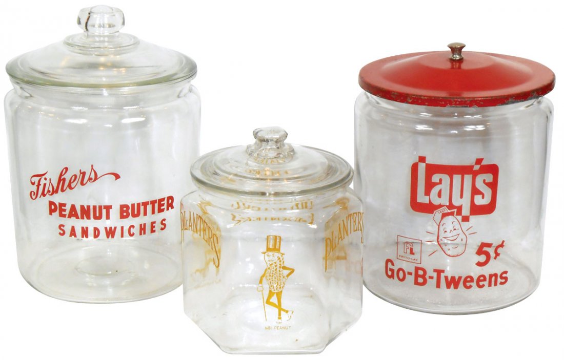 Advertising counter jars (3), Fisher's Peanut Butter: Advertising counter jars (3), Fisher's Peanut Butter Sandwiches w/glass lid, Lay's 5 Cent Go-B-Tweens w/metal lid & Planters 6-sided jar w/replacement glass lid, all VG & Exc cond, 9"H x 14"H.