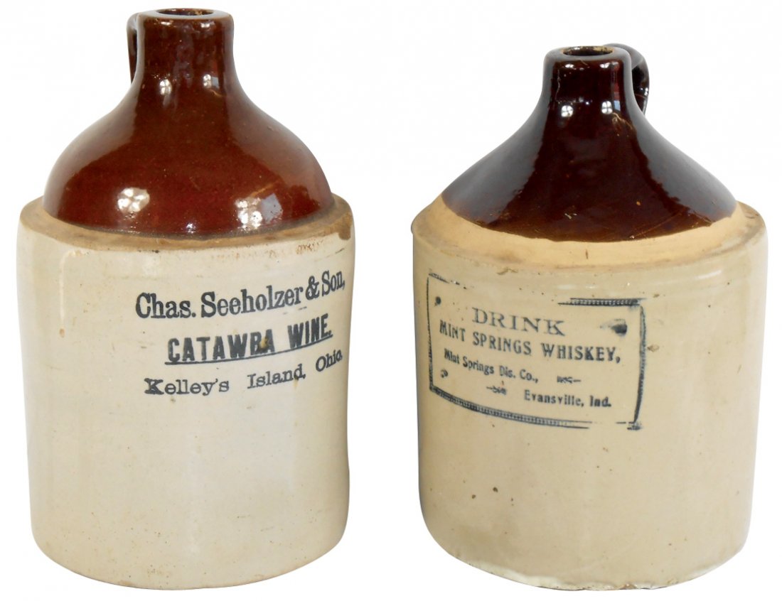 Stoneware advertising jugs (2), Chas. Seeholzer & Son,: Stoneware advertising jugs (2), Chas. Seeholzer & Son, Catawba Wine-Kelley's Island, OH, 2 shoulder chips & bottom crowsfoot & Drink Mint Springs Whiskey-Mint Springs Dis. Co.-Evansville, Ind, bottom 