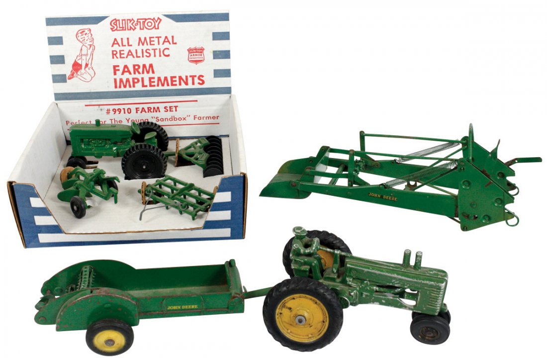 Toy tractor & implements (4), John Deere tractor,: Toy tractor & implements (4), John Deere tractor, spreader & loader, cast metal & Slik Toy #9910 Farm Set in display box, Slik in Exc cond, others Good+/VG cond, up to 11"L.