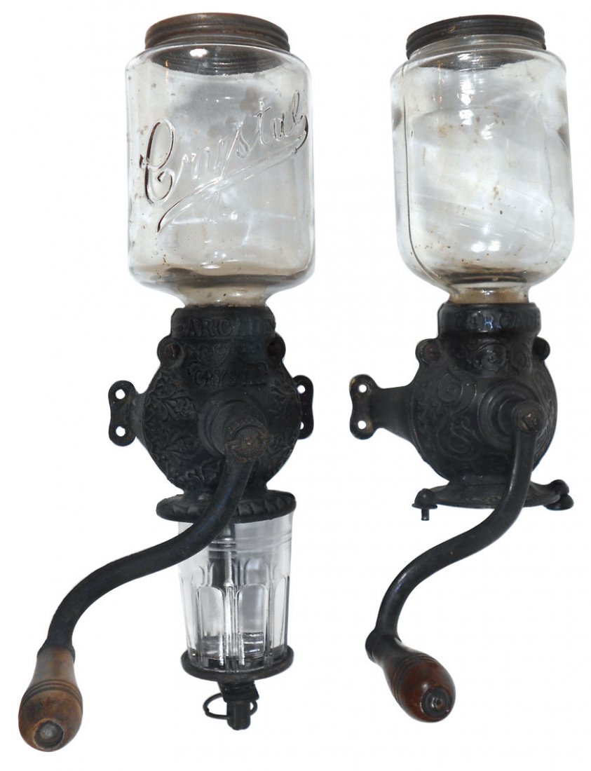 Coffee grinders (2), Arcade Crystal w/embossed lid &: Coffee grinders (2), Arcade Crystal w/embossed lid & orig catch cup, Exc cond, 17.5"H x 5"W & Arcade w/plain lid, missing catch cup & holder, VG cond, 16"H x 4.5"W.