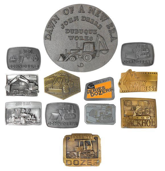 John Deere Dubuque Works desk piece & belt buckles: John Deere Dubuque Works desk piece & belt buckles (12), embossed cast iron desk piece representing 310 Series Backhoe, produced by E. Keefer Fdry-Dubuque, approx 250 made, c.1985 & 11 belt buckles re