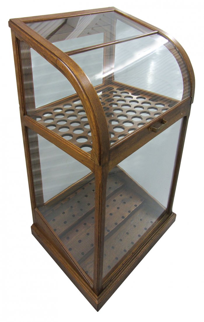 Clothing store cane or umbrella case, oak w/hinged: Clothing store cane or umbrella case, oak w/hinged curved glass lid, holes for approx 76 canes/umbrellas, castors for easy moving, Exc cond, 50"H x 27.5"W x 22"D.