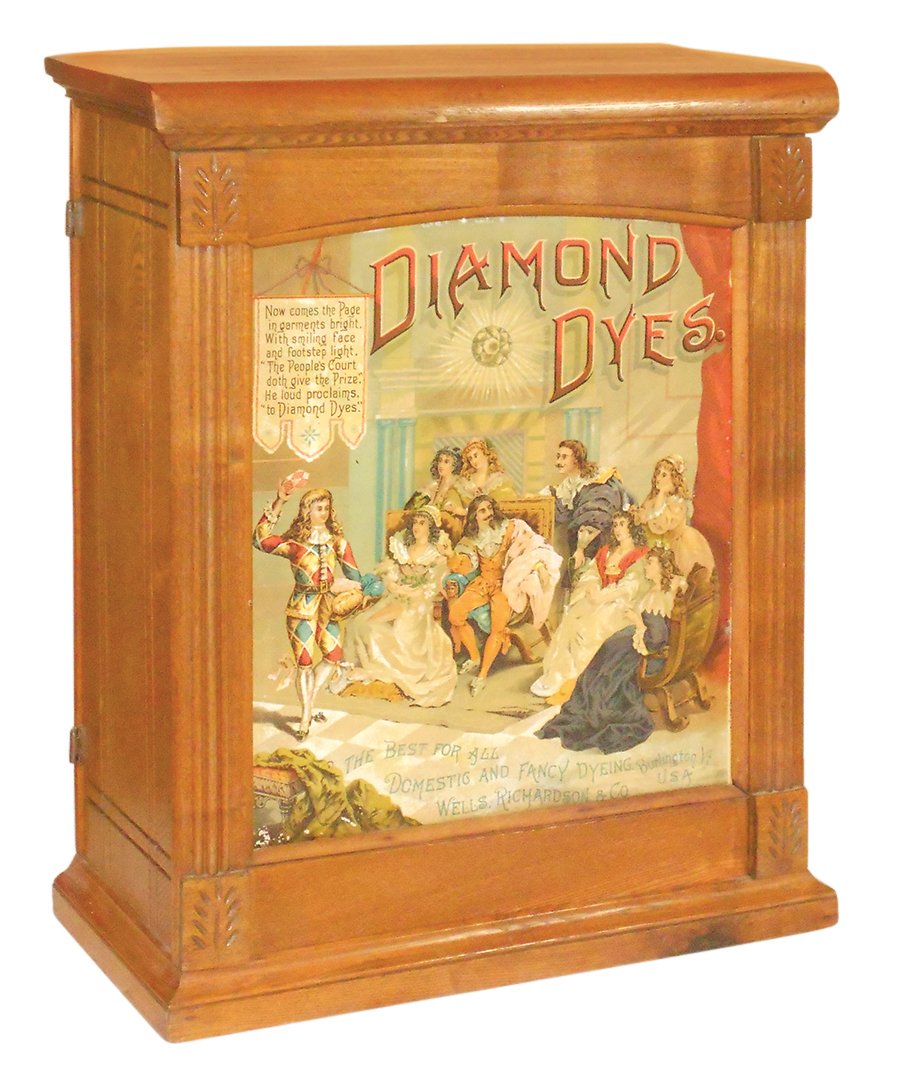 Country store Diamond Dyes cabinet, Court Jester, wood: Country store Diamond Dyes cabinet, Court Jester, wood w/tin litho insert, no interior shelves, o/wise VG+ cond, 27.5"H x 21"W x 10"D.