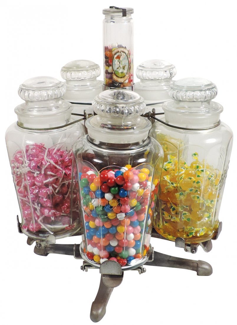 Candy jar counter display, cast iron rotating display: Candy jar counter display, cast iron rotating display w/5 embossed glass Bunte jars, center spindle w/smaller Bunte jar, outside jars rotate & tip down to dispense product, a very unusual & Rare early