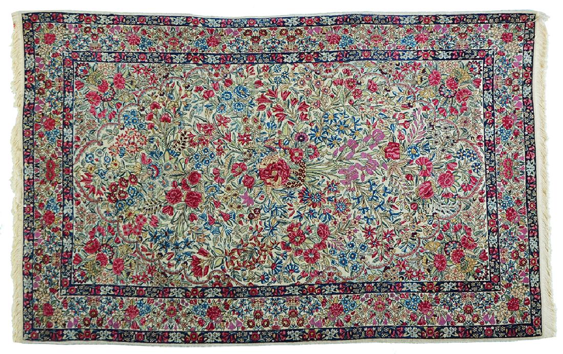 A PERSIAN ANTIQUE KERMAN RUG: Remarkable pattern with flowers in various tones on a white ground. 220x140 cm.