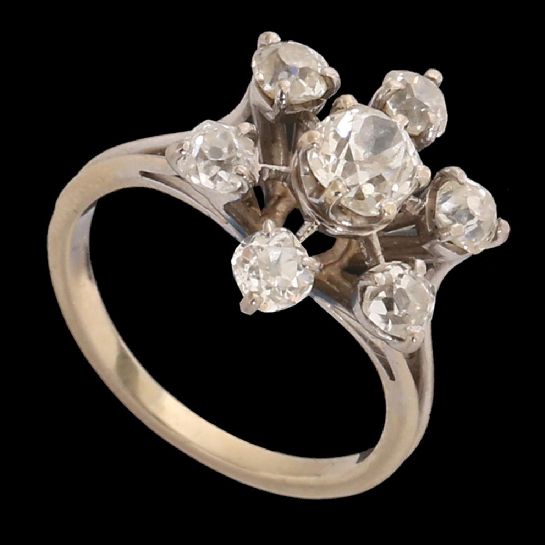 A RETRO, PLATINUM RING: flower shaped, set with a central diamond and 6 smaller diamonds around it. Total diamond weight is approx. 2.00 cts.