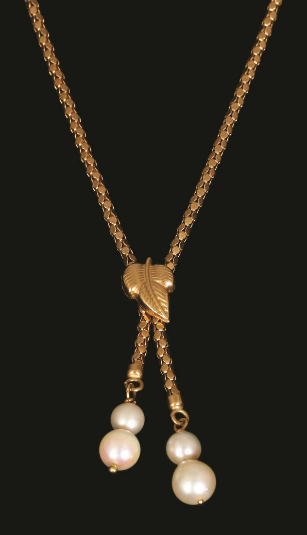 AN 18K GOLD NECKLACE: Decorated with gold leaf and 2 tassels set with pearls.