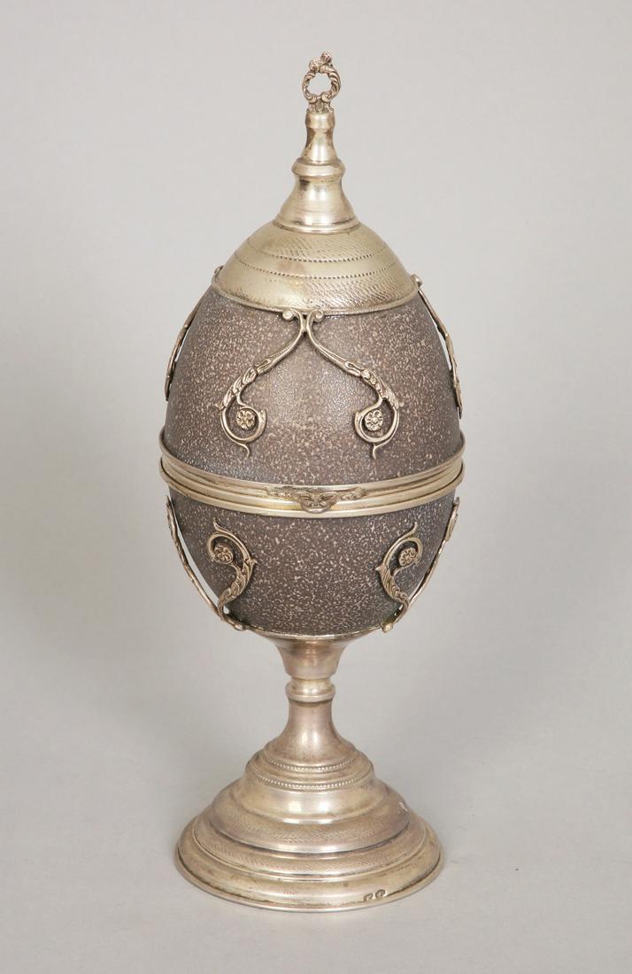 AN EGG FORM SCULPTURE DECORATED WITH SILVER: Likely Italy, post 1935. Marked. 25 cm high.