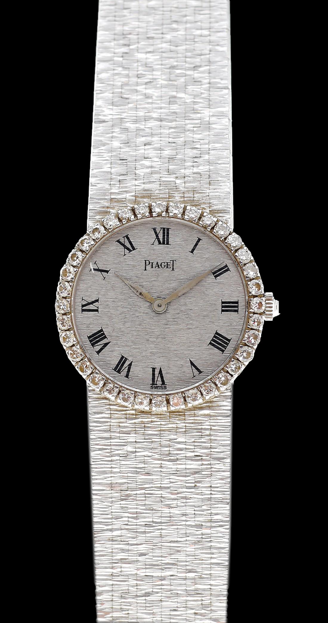 AN 18K WHITE GOLD PIAGET WRISTWATCH,: Mechanical mechanism, diameter: 23 mm. set with diamonds in the frame. An 18K white gold original Integral bracelet and buckle.
