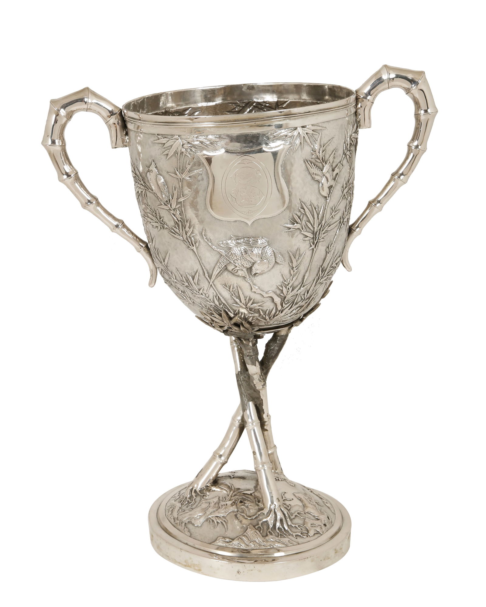 TUCK CHANG & COMPANY LTD. LARGE SILVER CUP: Shanghai, 1890–1915. Bambooware style. Decorated with fine repousse work of birds on bamboo branches and a heraldic medallion. With handles and feet in the form of bamboo branches. Signed. Weight: