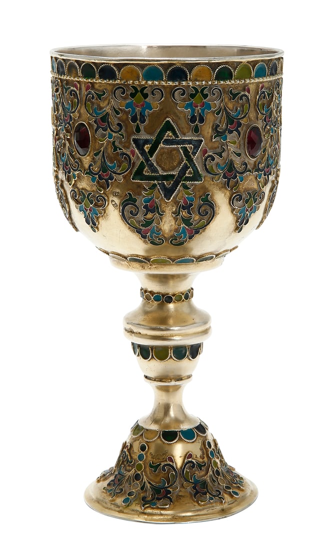 RUSSIAN SILVER KIDDUSH CUP: Moscow. Decorated with polychrome enamel in openwork cloisonne, featuring Stars of David and red stones. Gilded. Signed. Total weight approximately 336 g. Height: 17.5 cm.