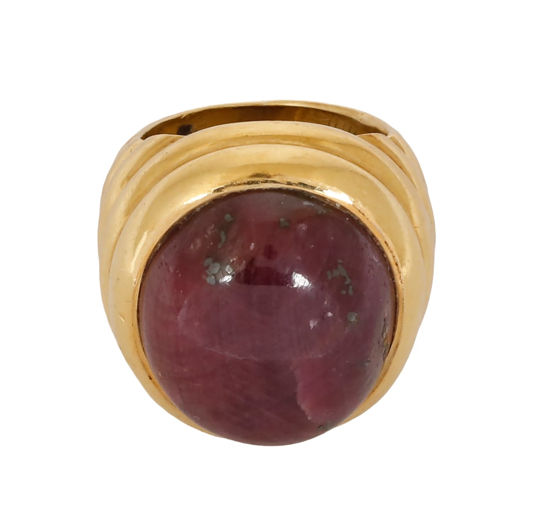 18K GOLD RING: Engraved and set with an oversized cabochon-cut ruby. Size US 6. This ring can be resized. Weight approx. 32 grams.