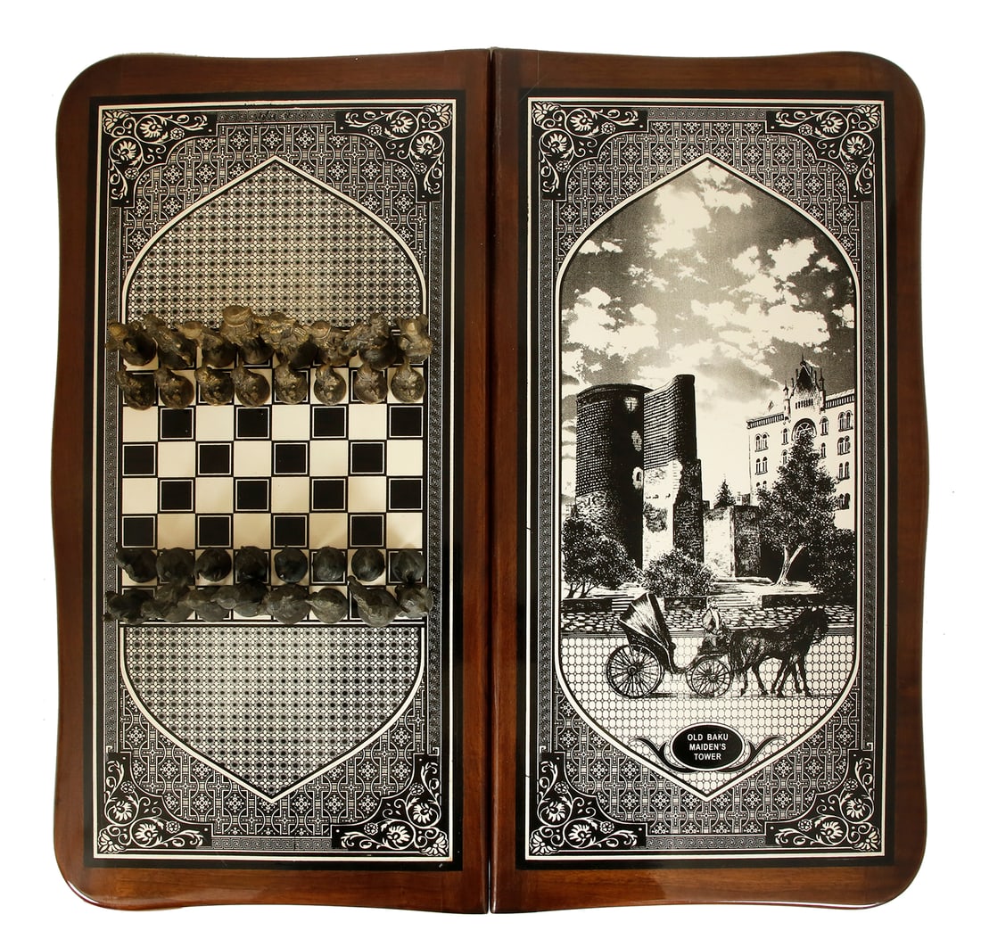 AZERBAIJANI CHESS AND BACKGAMMON BOARD: Baku, 20th century. Made of wood, decorated with prints of the Old City and the Maiden Tower. Game pieces in the form of soldiers, made of bronze and wood. Board length: 66 cm.