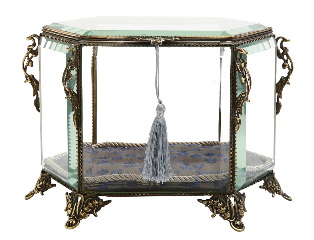 FRENCH LUXURIOUS JEWELRY BOX, EARLY 20TH CENTURY: Late victorian style. made of glass and brass fittings decorated with leaves and flowers. includes a fabric cushion and Golden cord. set on six brass feet. glass panels. Total width: 30 cm.