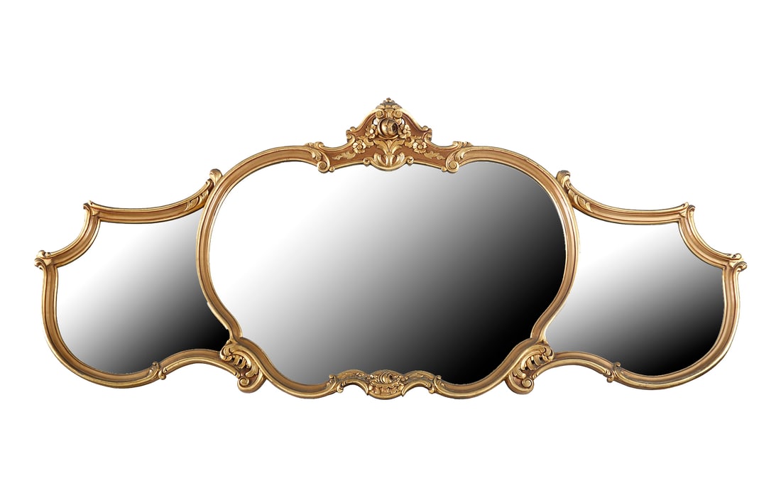 FRENCH MIRROR: Neo-rococo style. Divided into three panels. Gilt wood frame. Decorated with carved crests of flowers, foliage, and rocaille lines. With a finial. Dimensions: 86×195 cm.