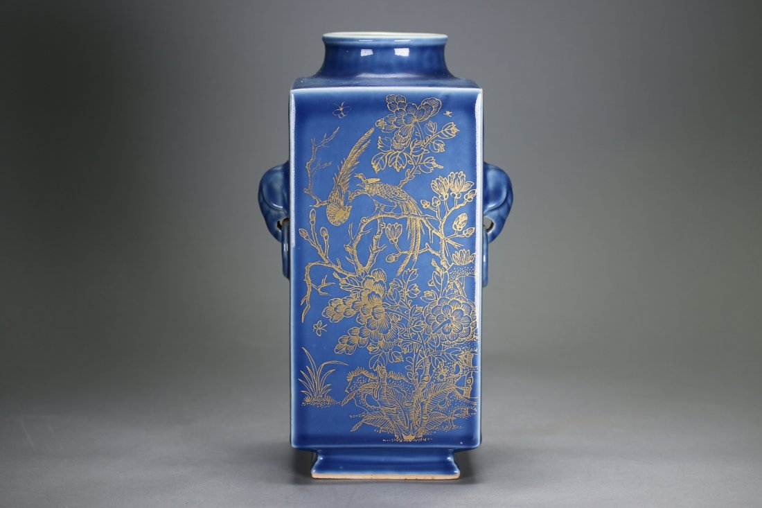 A Blue-Glazed Gilt Rectangular "Cong"Vase,Qianlong: The bottle vase form in rectangle raises from a glazed square foot. Decorated with golden painting on all four sides feature birds on tree branches among delicately painted flowers. Two ear-like eleph