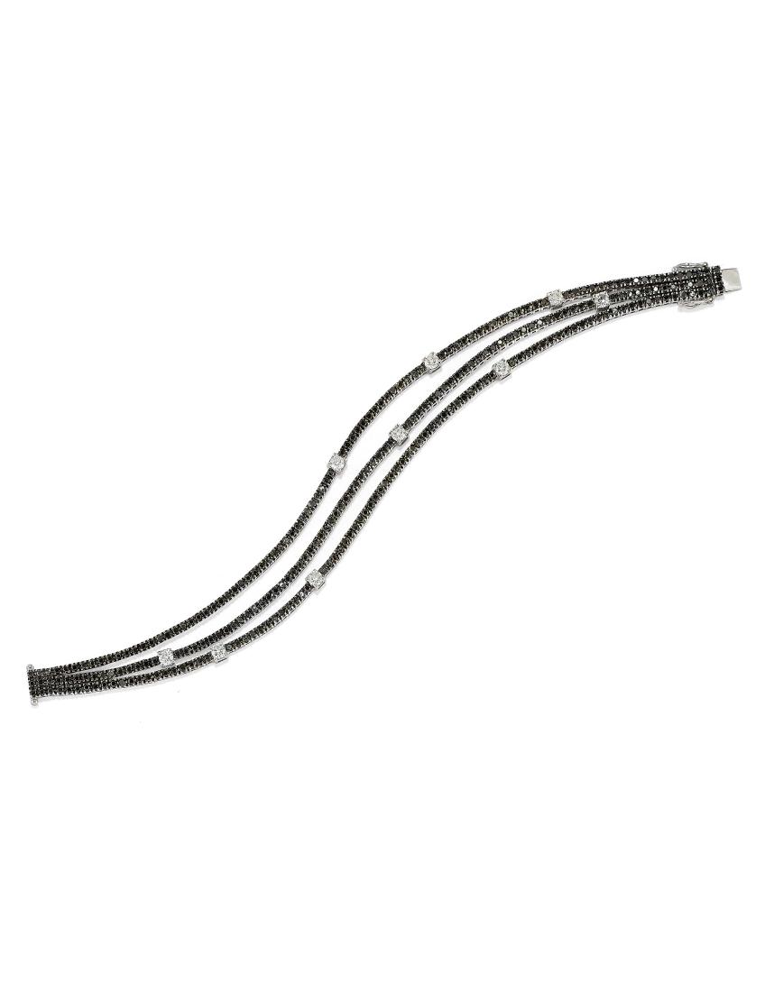 BRACCIALE SEMISNODATO IN ORO E DIAMANTI, CRIVELLI: realizzato con tre file di brillanti neri alternati a brillanti incolori, punzone 750 e dell'orafo, il peso delle pietre iscritto sulla chiusura, cts 4. i diamanti neri e cts 0.98 i diamanti incolori