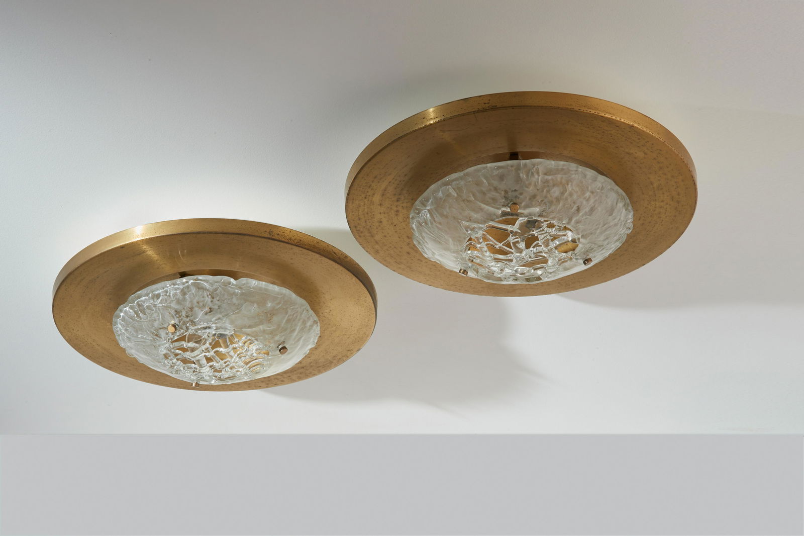 ANGELO BROTTO (2): Coppia di lampade da parete. Ottone spazzolato, vetro colato. Produzione Esperia anni '60. cm 20x50 Etichetta della manifattura. Buone condizioni generali, piccole righe e trascurabili segni di usura.