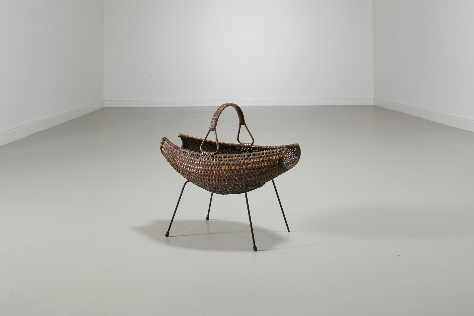 MANIFATTURA ITALIANA: Portariviste. Tondino metallico smaltato, vimini intrecciato. Italia anni '50. cm 52x56x36 Discrete condizioni generali. Segni di usura e leggere ossidazioni alla struttura in metallo. Mancanze e graf
