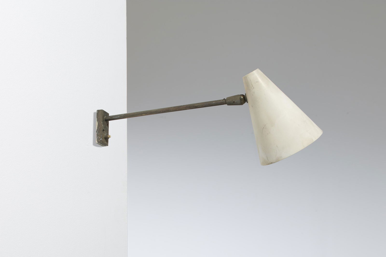 GIUSEPPE OSTUNI: Lampada da parete. Ottone, alluminio verniciato. Produzione Oluce anni '50. Massima estensione cm 52. A WALL LAMP BY G. OSTUNI Buone condizioni generali. Piccole righe, leggeri segni di usura. Ottone