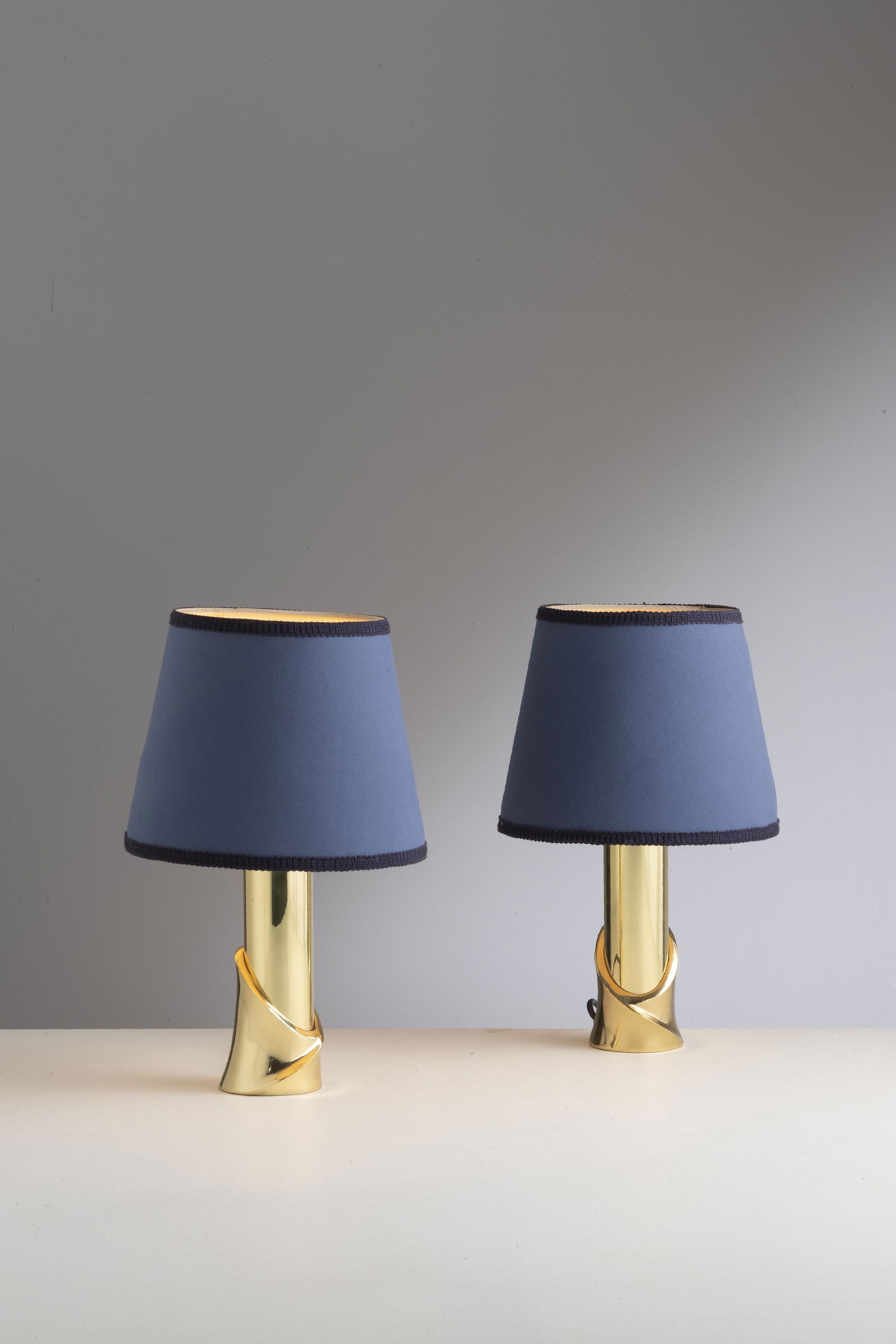 LUCIANO FRIGERIO: Coppia di lampade tavolo. Ottone, tessuto. Produzione Frigerio di Desio, anni '70. cm con paralume 41x9 A PAIR OF TABLE LAMPS BY FRIGERIO Ottime condizioni. Righe, graffi, segni d'usura, paralumi non
