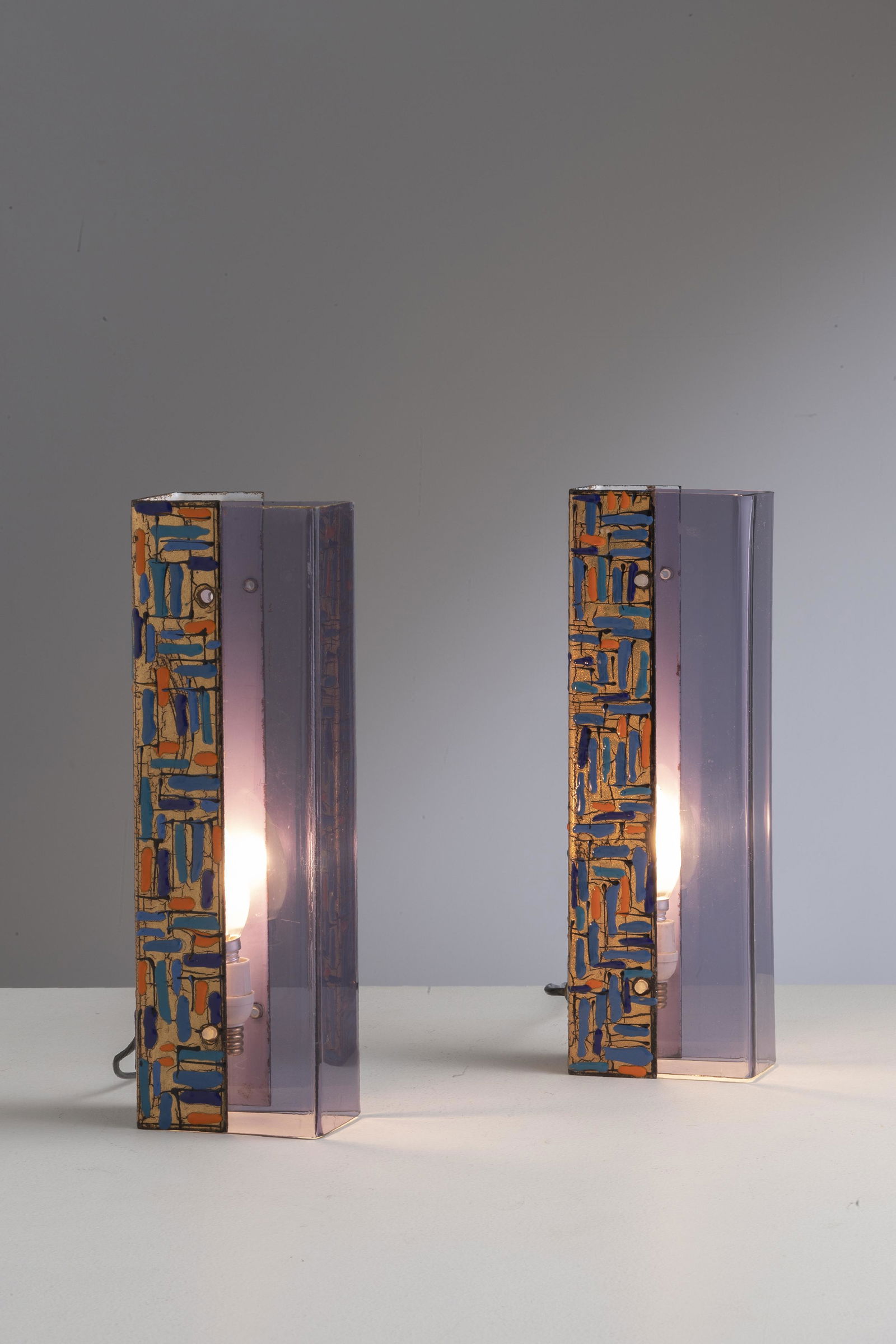 ANGELO BROTTO ( ATTRIB. A): Coppia di lampade da tavolo. Rame smaltato, perspex colorato. Produzione Esperia anni '60. cm 33x11x6,5 A PAIR OF TABLE LMAPS ATTRIBUTED TO A. BROTTO Buone condizioni generali. Piccole righe, normali