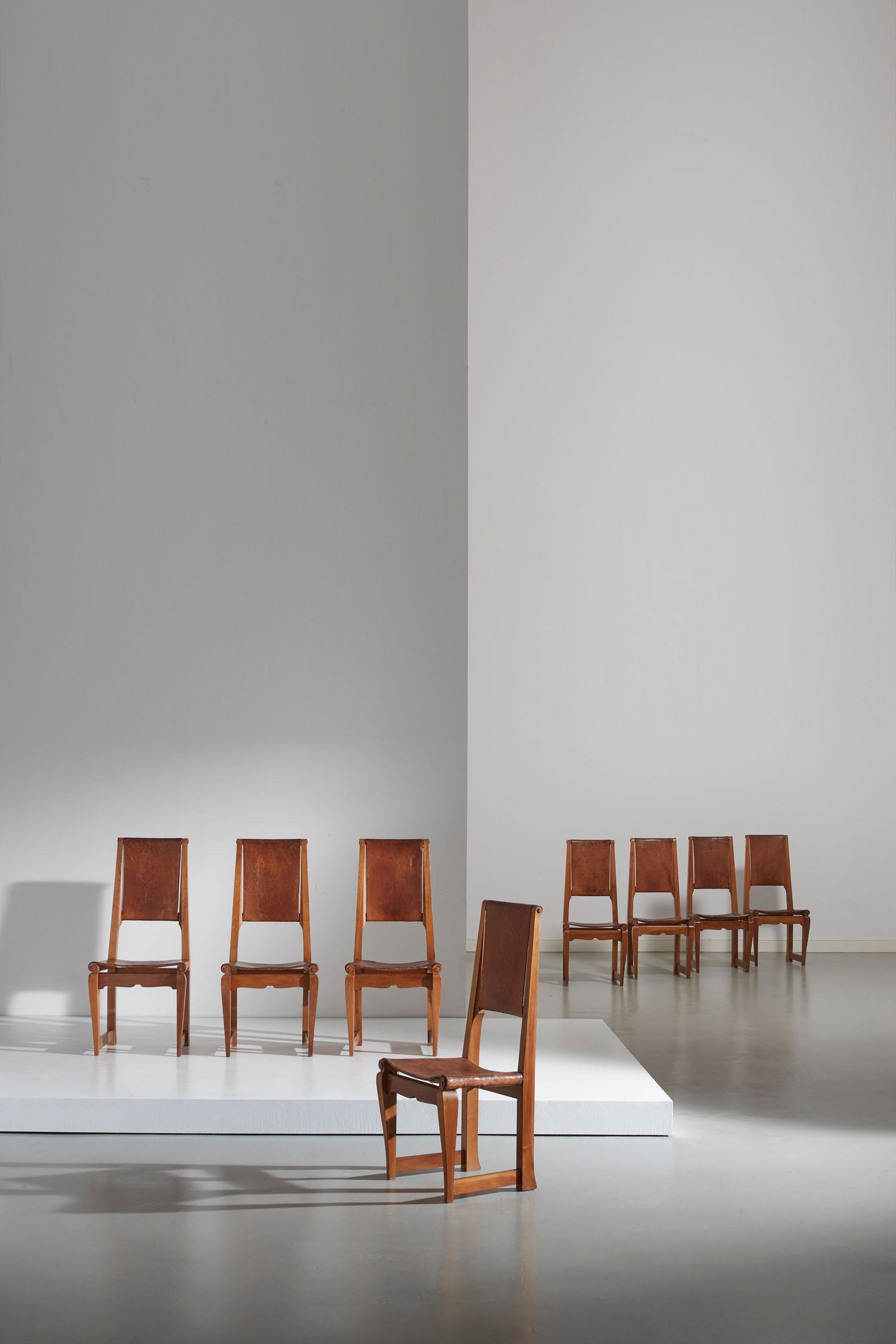 MANIFATTURA ITALIANA: Otto sedie Art Deco'. Legno di noce massello e cuoio. Italia XX sec. cm 108x50x48 EIGHT ITALIAN CHAIRS