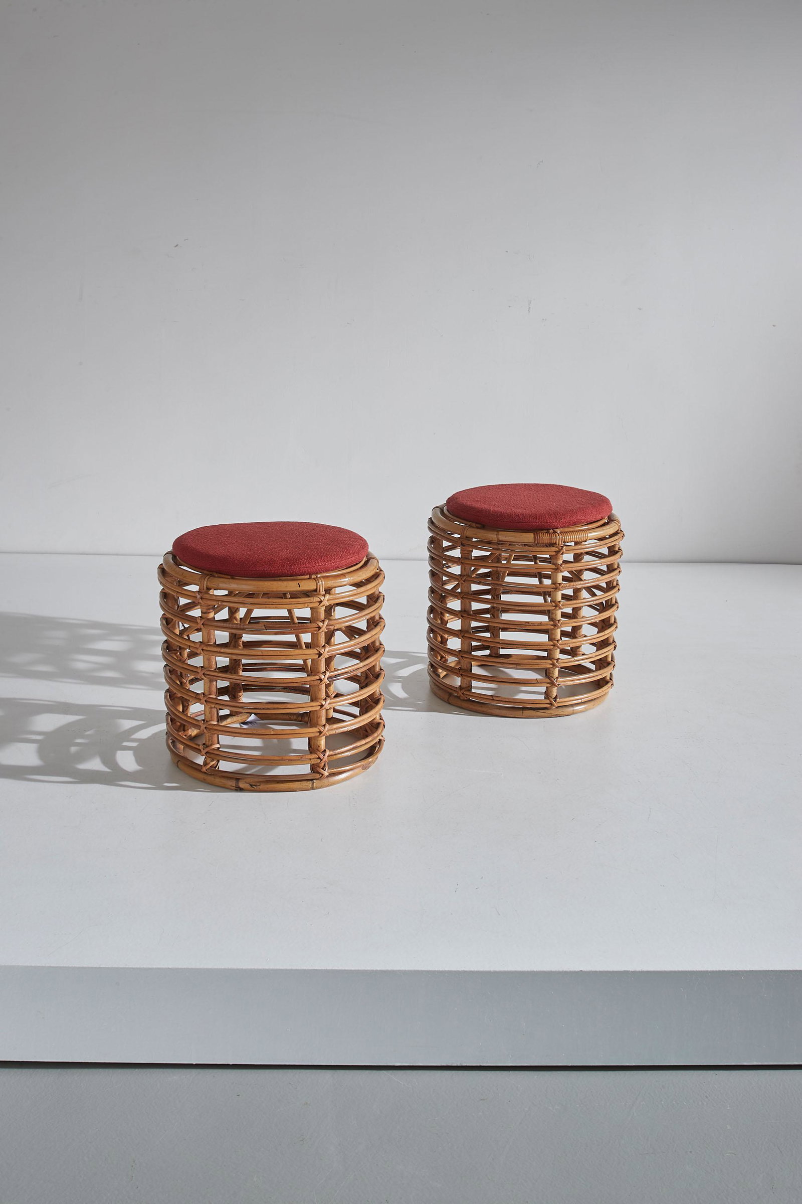 TITO AGNOLI: Coppia di sgabelli. Canna d'India, midollino, tessuto imbottito. Italia anni '50 ca. cm 45x42 A PAIR OF STOOLS BY T. AGNOLI
